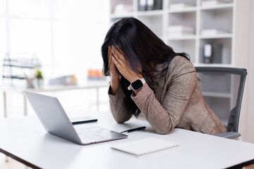 Stressed tired dizzy young lady, asian business woman employee office worker touching head feeling sad, fatigue, headache migraine pain or stress, exhausted after computer work, having burnout.
