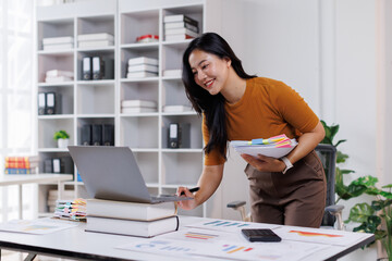 Business woman hands of paper files for searching and checking on laptop unfinished document...