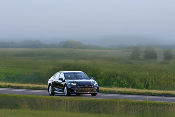 Fototapeta premium Shiny new automobile driving on open highway