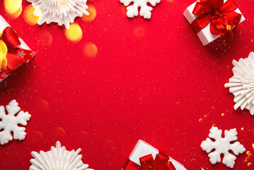 Merry Christmas and Happy Holidays greeting card, frame, banner. New Year. White, red Christmas ornaments and gifts on red background top view. Winter xmas festive holiday theme.