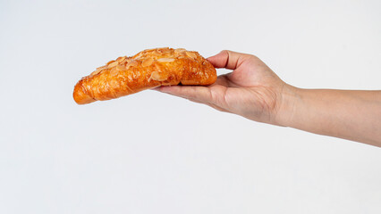 Fresh Rose Croissant with Almonds and hand on White Background