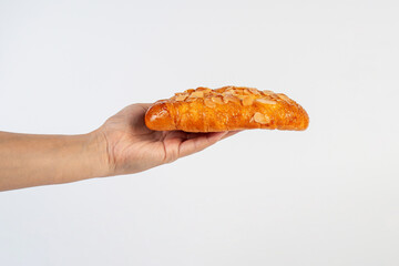 Fresh Rose Croissant with Almonds and hand on White Background