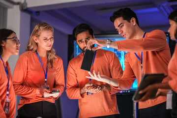 A diverse team of young innovators in a tech lab presents a new smartphone prototype, enthusiastically brainstorming its next-generation design and user interface for a future product launch.