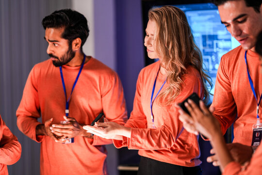A diverse man and woman present smartphones with blank screens, perfect for a new app mockup. A showcase for mobile communication technology in a modern office setting.