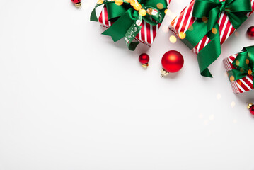 Merry Christmas and Happy Holidays greeting card, frame, banner. New Year. Red green Christmas decoration and gifts, presents on white background top view. Xmas holiday festive theme.