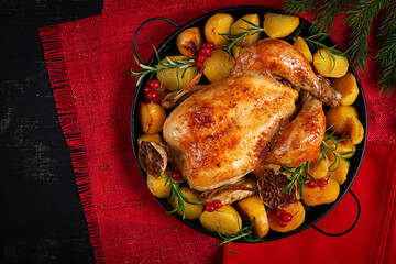 Roasted chicken with potatoes and Christmas decoration. Baked chicken or turkey. Table setting. Top view, flat lay
