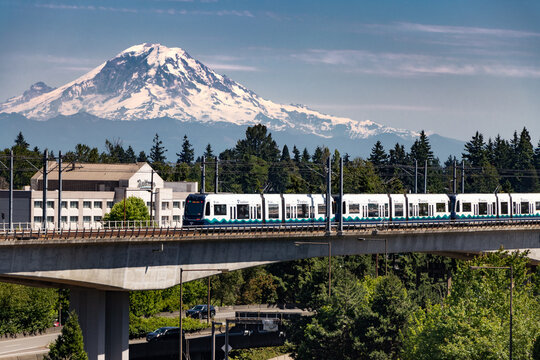 A Seattle Sound Transit Link light rail train on an elevated track with Mount Rainer in the background - Seattle, Washington, USA	
