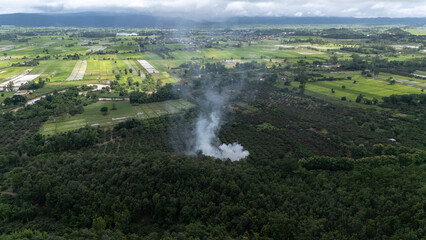 Aerial view of burning fire on agriculture field in rural Thailand. Farmers in many parts of the world set fire to cultivated fields to clear stubble, weeds and waste before sowing a new crop.