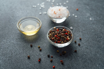 Oil, himalayan salt and pepper on a dark stone background