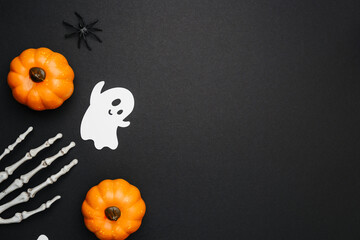 Pumpkin ghost and spider decoration on a black background, creepy Halloween celebration