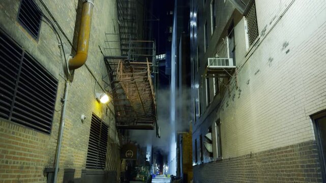 Panning down shot of a steamy ally at night in Chicago, Illinois.