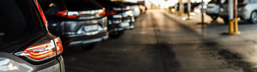 Cars parked in a row at a parking lot with a blurred background