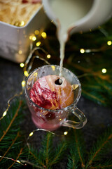 Festive Dessert With Marshmallows, Whipped Cream, and Milk Being Poured in a Cozy Holiday Setting With Twinkling Lights
