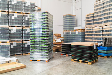 Pallets of empty and filled beer bottles and cans prepared for production or distribution in an industrial warehouse