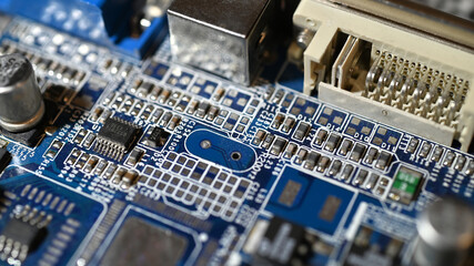 Close-up view of an electronic circuit board with connectors, resistors, and components on a blue printed circuit.