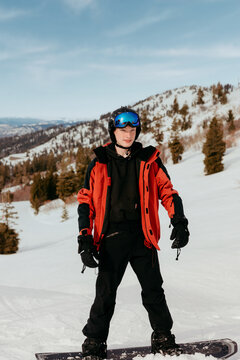 Young snowboarder standing ready on mountain slope