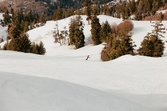 Snowboarder riding down snowy mountain slope