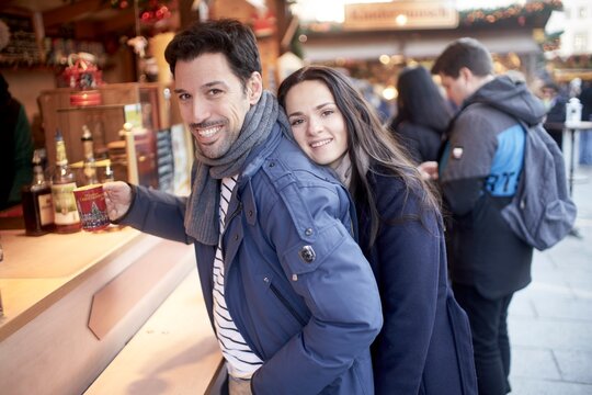 couple at christmas market buying fruit punch or hot spiced wine