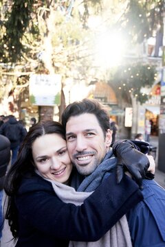 happy couple in winter clothes in city with christmas decorations