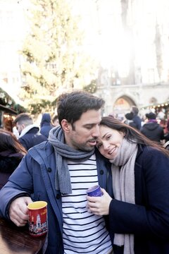 couple with hot spiced mulled wine punch at christmas market