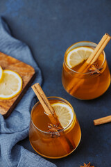 Warm spiced drinks with cinnamon, lemon, and star anise in glasses © reddish