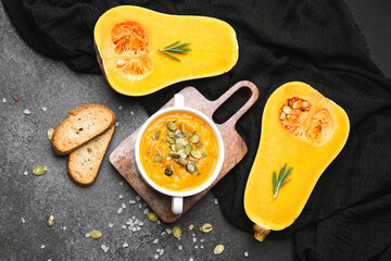 Golden squash soup with seeds, rosemary, and toasted bread on a rustic table
