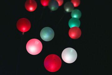 Floating colorful spheres with light illumination against dark background.