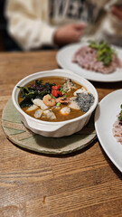 Enjoying a special Chinese herbal spice curry with pork, beef, seafood, shrimp, scallop, and oyster, served with organic vegetables and multigrain rice at a traditional Japanese family restaurant