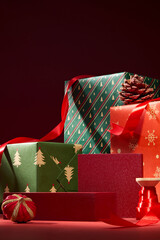 Red and green wrapped gift boxes stacked with holiday ribbon. Cozy Christmas composition with soft lighting and festive charm. Advertising photo for Christmas day