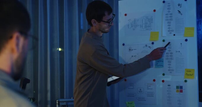 Team adult male engineer develop present AI robotics hand project at tech workspace night. Artificial intelligence, collaboration support prototype development, robotic, machine learn, training.