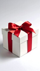 Obraz premium A white square gift box, tied with a vibrant red satin ribbon, on a light background