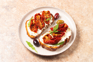 Toast with cream cheese and dried tomatoes. Open sandwich with arugula, bread, tomatoes, olives and oil. 