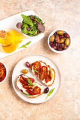 Toast with cream cheese and dried tomatoes. Open sandwich with arugula, bread, tomatoes, olives and oil. 