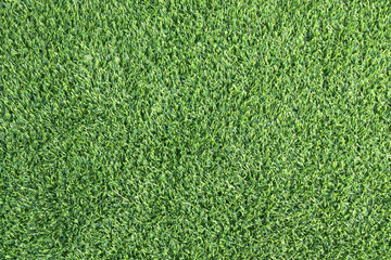 close-up of a lush, green artificial turf. The synthetic blades of grass are perfectly aligned and...