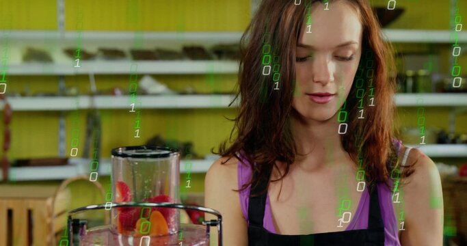 Juice attendant in purple top and apron blending fruit in juicer behind counter, green code overlay - Powered by Adobe