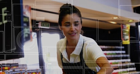 Leaning store clerk handing item over retail counter in supermarket, with striped apron, exit sign