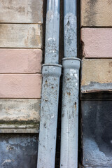 Weathered pipes against a textured wall in a close up architectural view