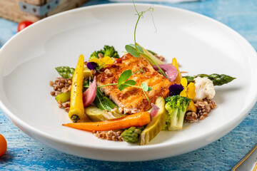 Seared salmon fillet served with grains and seasonal vegetables