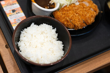 Tonkatsu set with big piece deep fired sirloin pork and streamed rice, famouse Japanese cuisine that served in tray. Food object with selective focus. 
