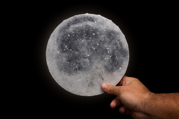 Man holding a round, glowing painting of the moon. Round painting of the moon. Moon painting. Acrylic art. Painting on canvas © Luka