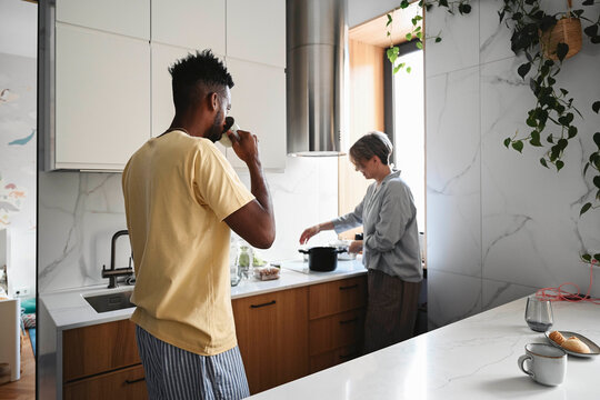 Couple cooking and enjoying breakfast together in modern kitchen