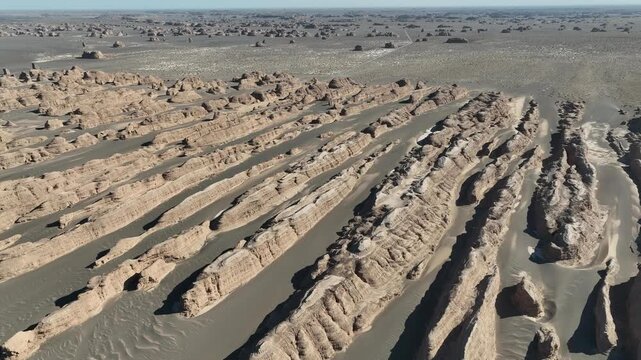 Aerial view of the stark Yardang landforms contrasting with the desolate desert landscape, creating an otherworldly vista of rock formations, Gobi Desert, China.