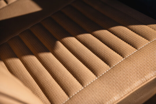 Close-up view of car vinyl seat - beige-brown basket weave vinyl in 1960s car. 