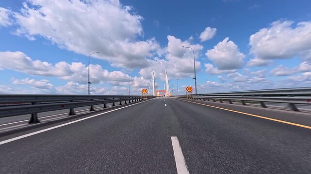 Warning signs before road repairs on a bridge. View from a moving car of the road and bridge.