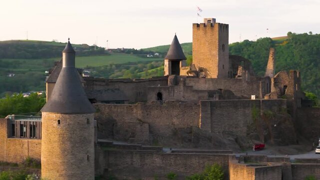 bourscheid castle ch&acirc;teau de green valley cover hills behind walls towers views castle&rsquo;s exterior structure to left right up close circling drone luxembourg 
