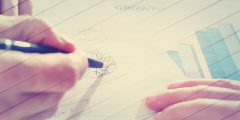 Hand pointing a pen on a diagram, geometric pattern