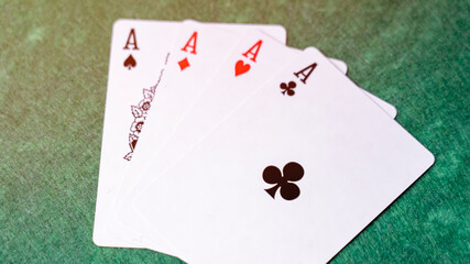 A deck of playing cards with the top card showing the Ace of Spades. The other three cards are the Ace of Hearts, the Ace of Diamonds, and the Ace of Clubs