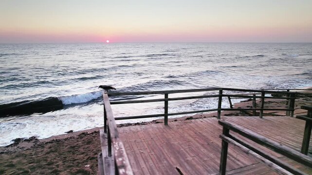 Sunrise Serenity: Weathered Stairs on Long Beach with Waves Lapping the Shore in Iskele, Northern Cyprus
