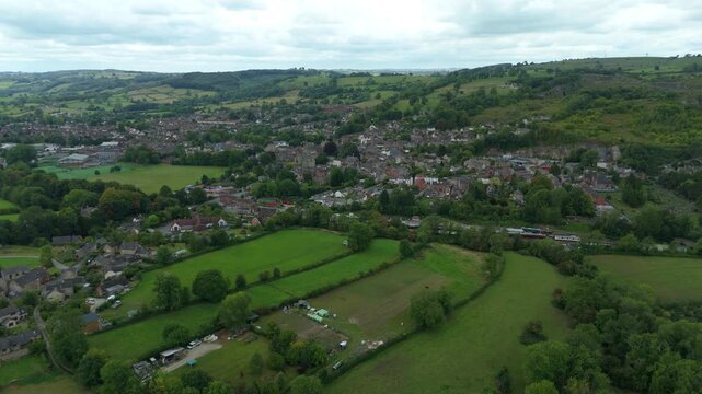 Aerial view of the town of Matlock, nestled between rolling green hills, where buildings contrast with lush fields, Matlock, England, United Kingdom.