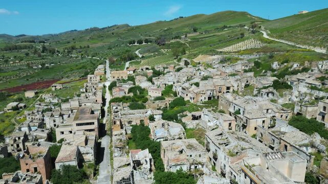 Aerial drone footage of old Poggioreale, Sicily: ghost town ruins abandoned after the 1968 earthquake, surrounded by hills and silence. Perfect for history, decay, and documentary projects.